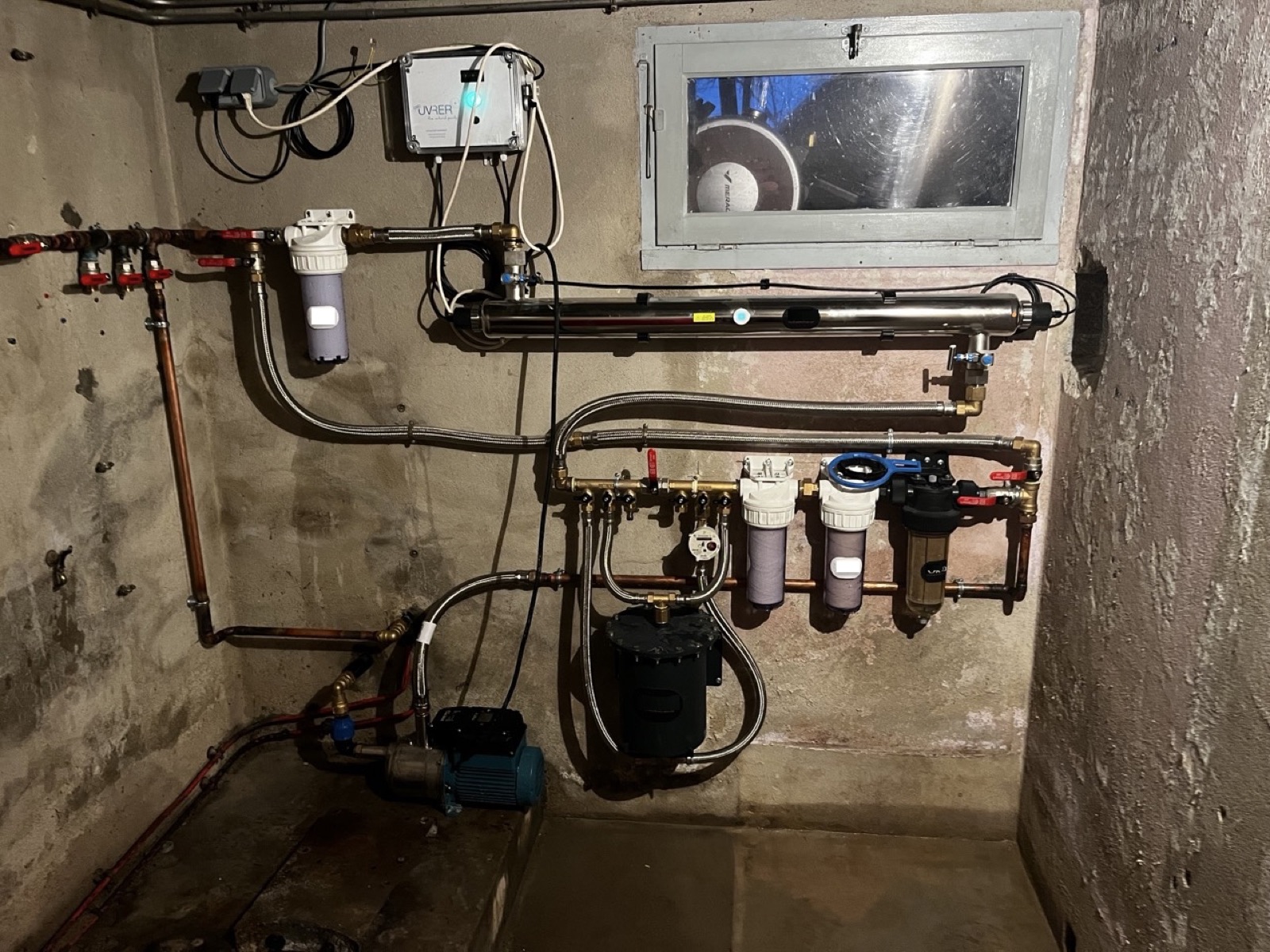 Installation de filtration d'eau chez un client, montée près d'une fenêtre