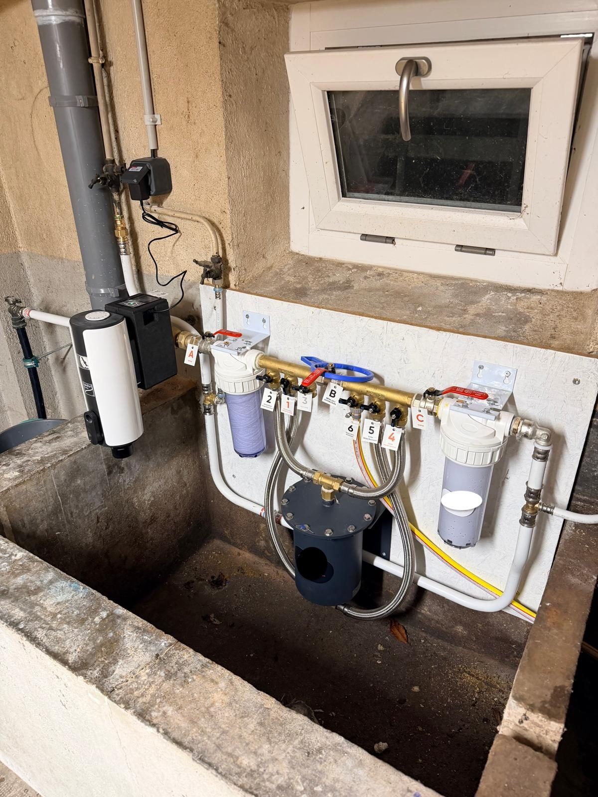 Installation de filtration d'eau près d'un ancien bac en pierre, en dépendance