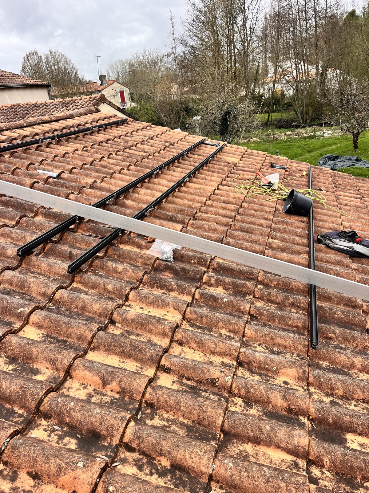 Rails de fixation posés sur toiture en tuiles avant la pose des panneaux
