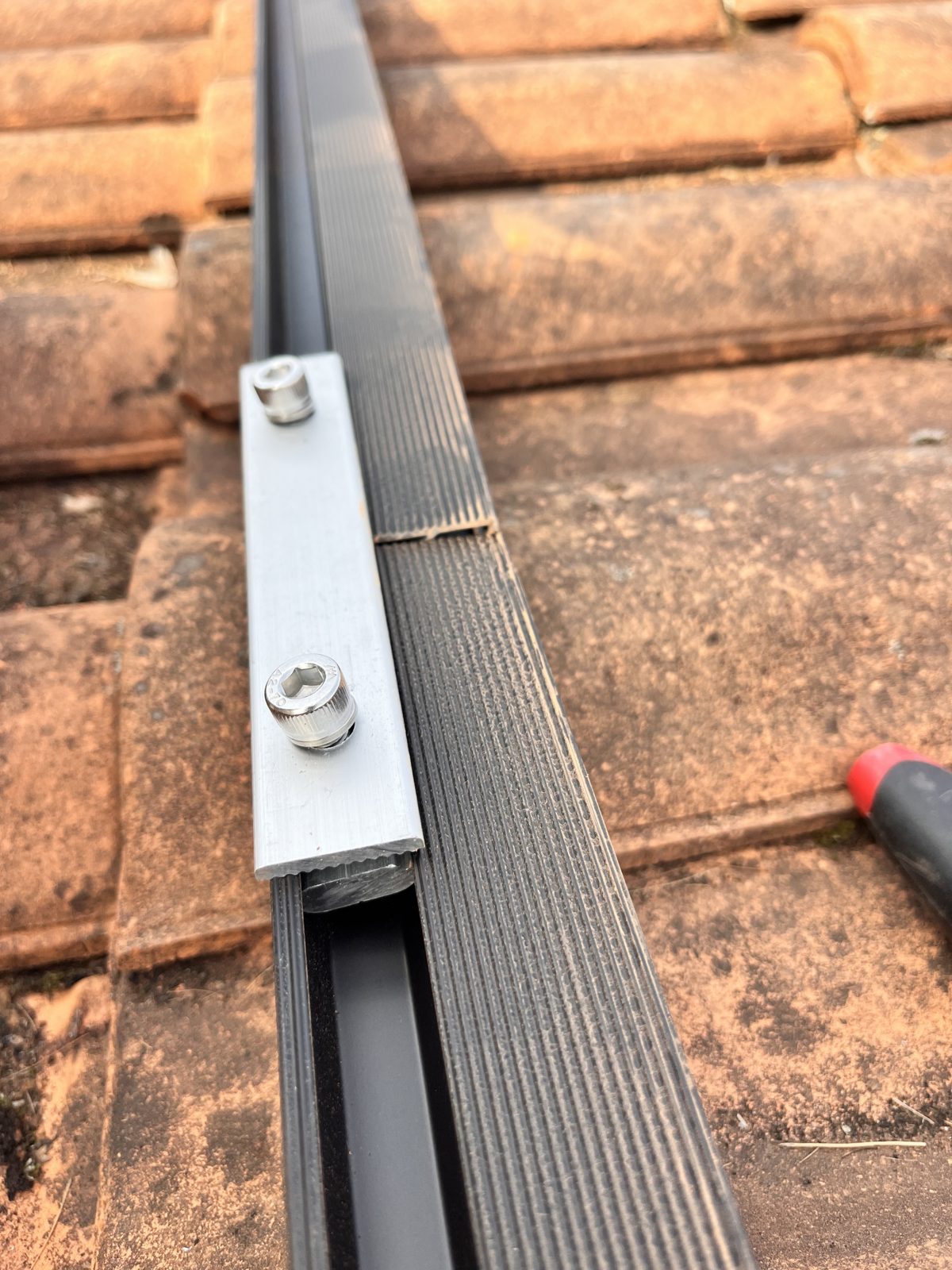 Détail d'une fixation de rail de montage sur tuile